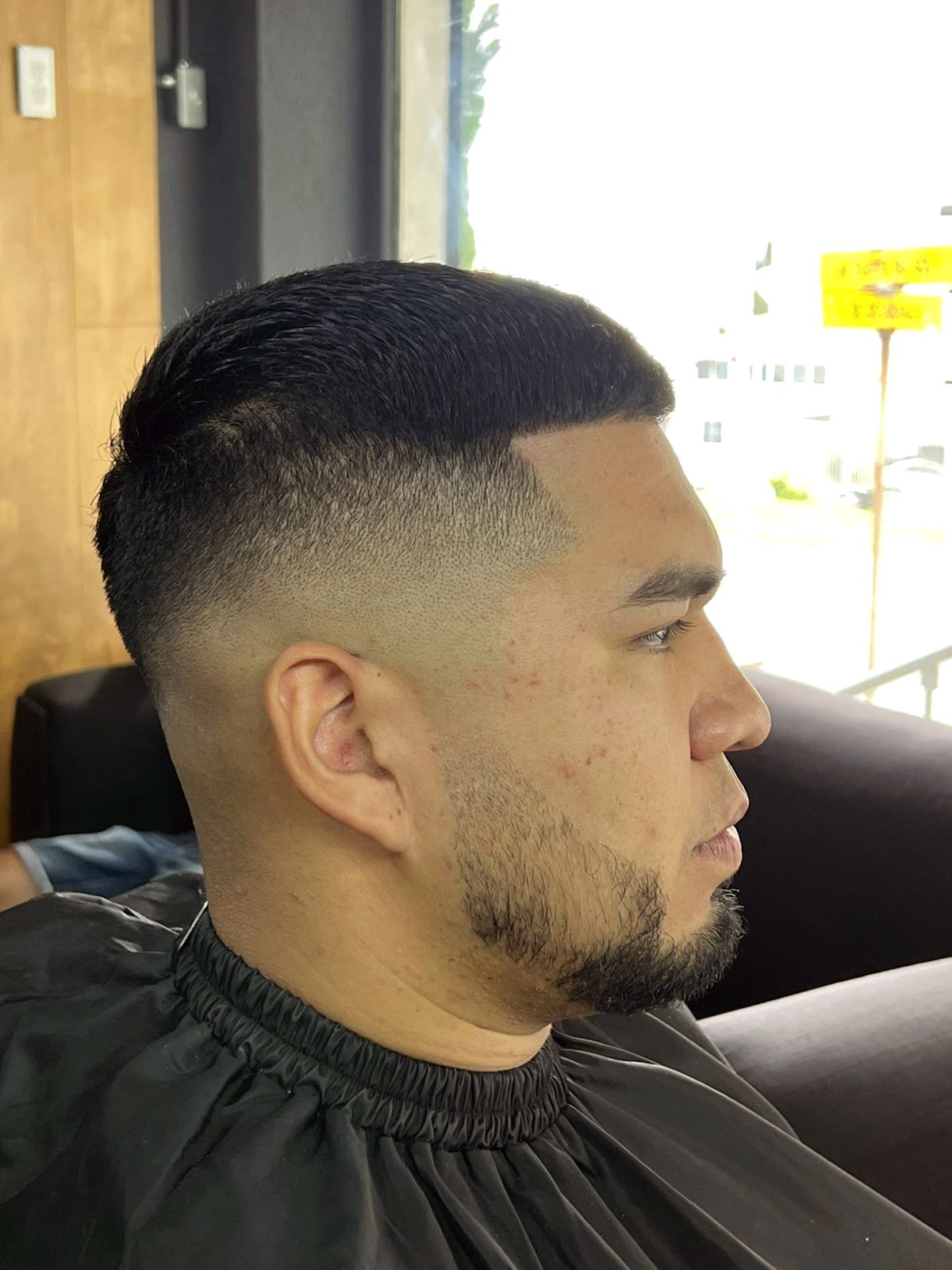 Low fade con barba perfilada, vista de perfil